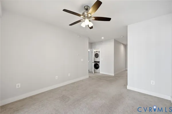 an empty room with ceiling fan and window