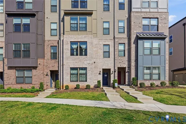 a view of a brick building with many windows and yard