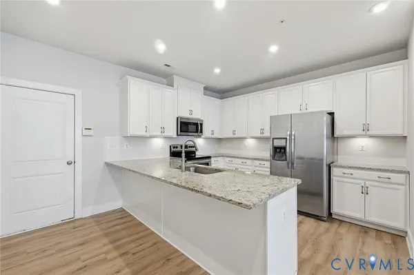 a kitchen with refrigerator cabinets and wooden floor