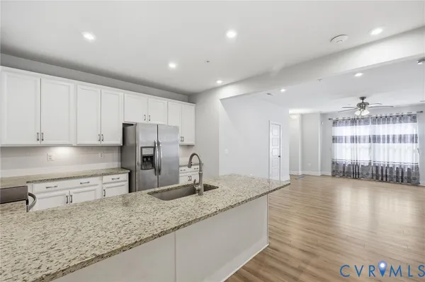 a kitchen with stainless steel appliances granite countertop a sink refrigerator and cabinets