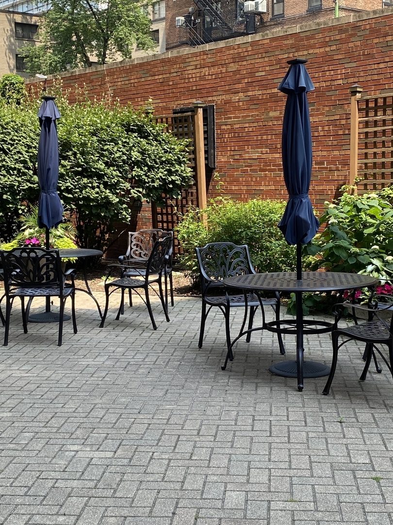 2909 North Sheridan Road, Unit 805 Chicago, IL 60657 - Photo 34 of 39 a view of a patio with table and chairs potted plants and floor to ceiling window