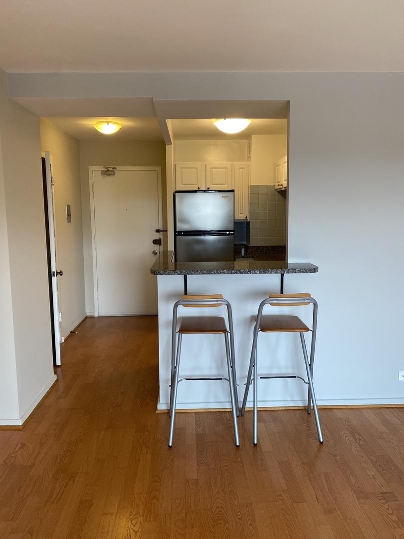2909 North Sheridan Road, Unit 805 Chicago, IL 60657 - Photo 6 of 39 a living room with furniture and a flat screen tv