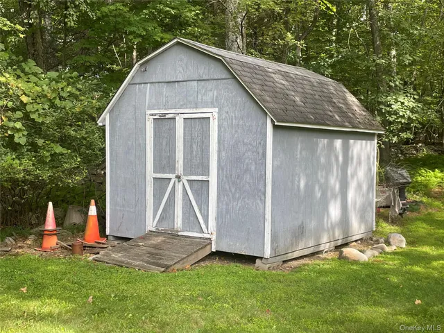 a view of backyard with a barn and a large tree