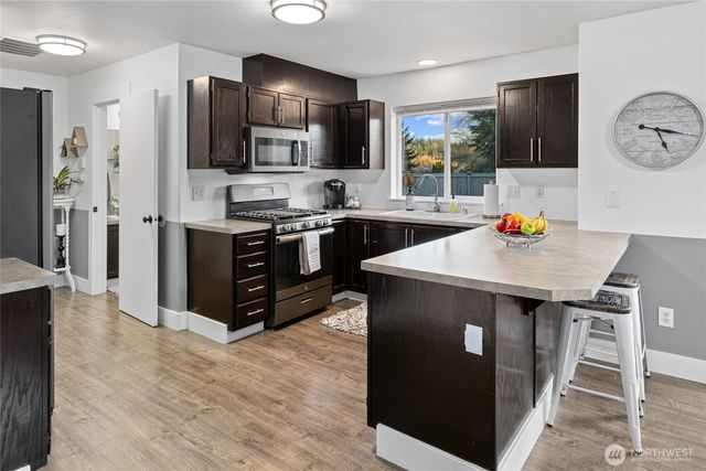 a kitchen with stainless steel appliances granite countertop a sink stove and refrigerator