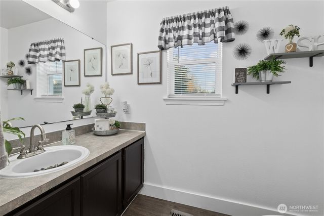 a bathroom with a granite countertop sink a mirror and vanity