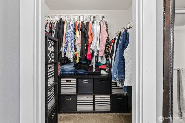 a view of walk in closet with clothes