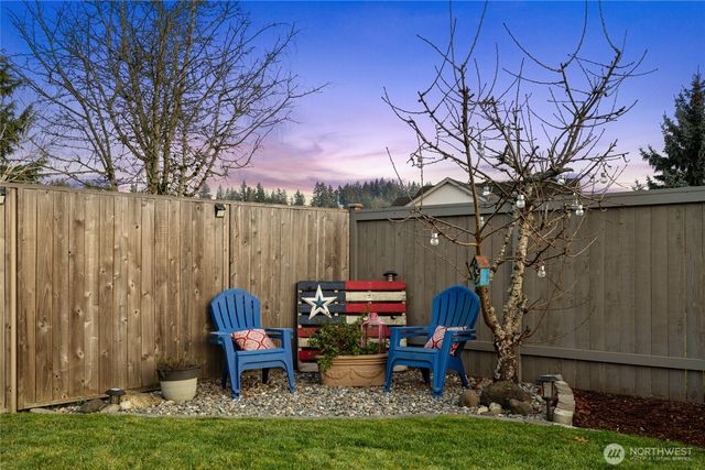 a backyard of a house with fountain table and chairs
