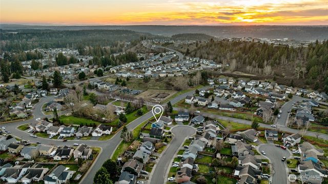 an aerial view of residential houses with outdoor space and trees
