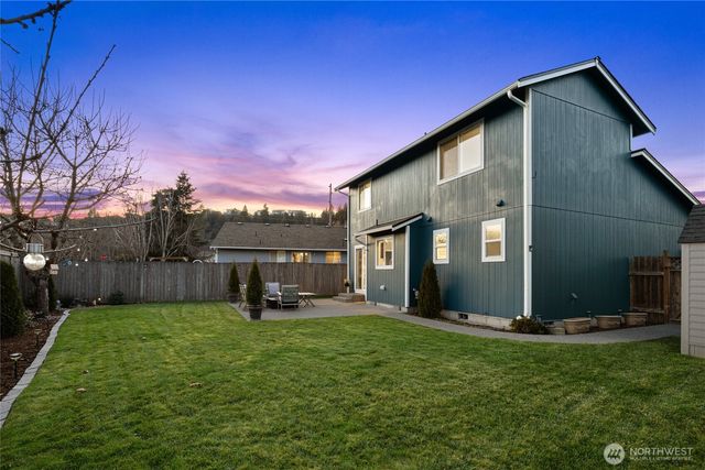 a front view of a house with a yard and trees