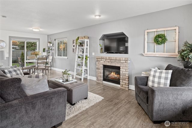 a living room with furniture a flat screen tv and a fireplace
