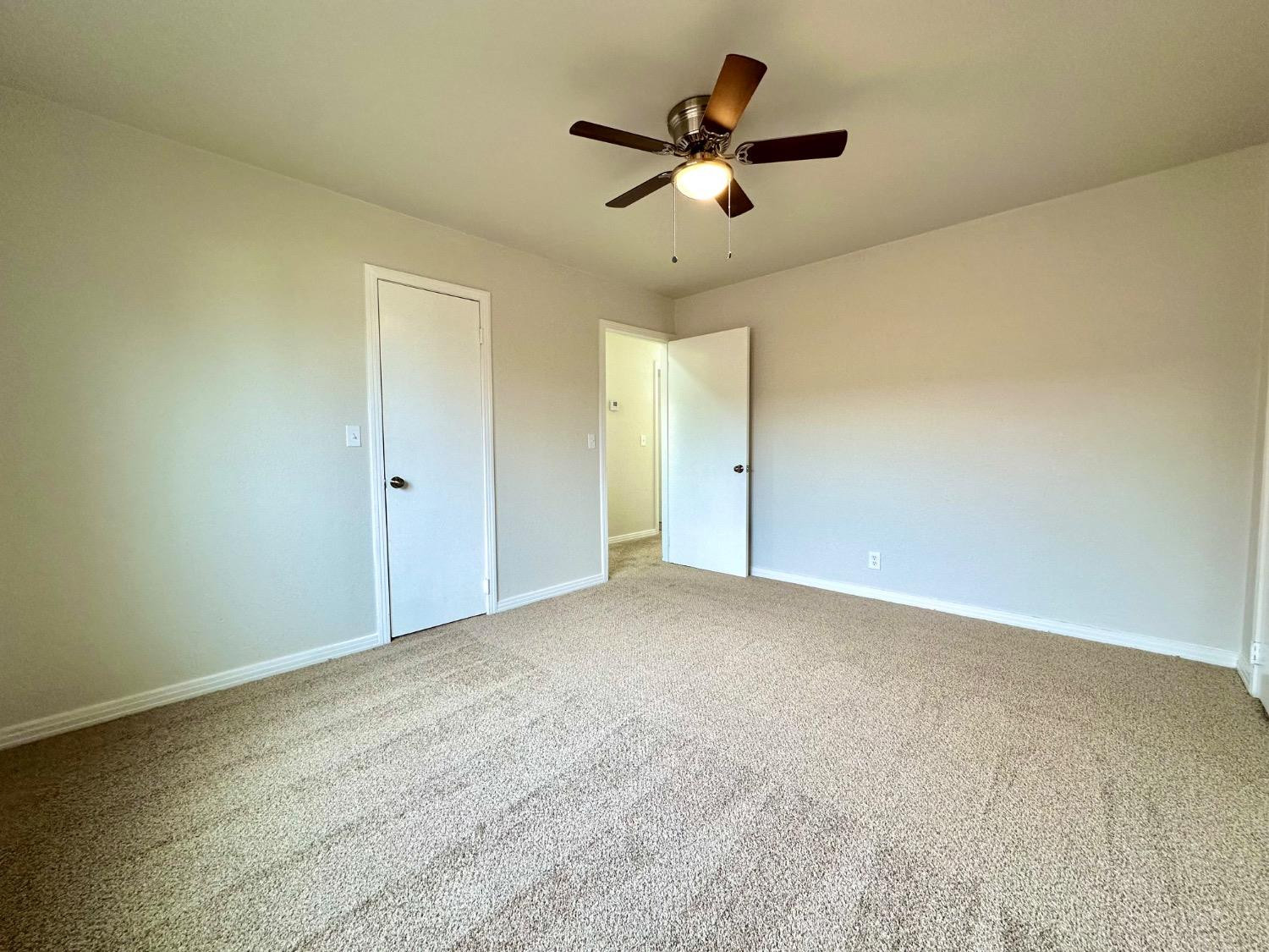 101 15th Street Levelland, TX 79336 - Photo 12 of 29 an empty room with a ceiling fan and window