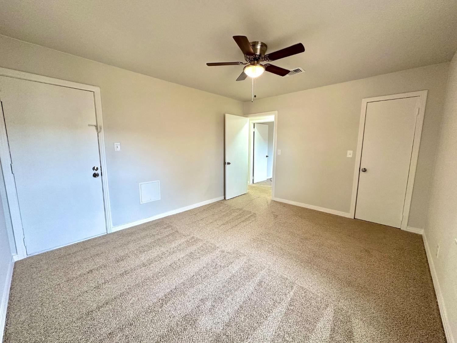 101 15th Street Levelland, TX 79336 - Photo 13 of 29 a view of a big room with wooden floor and a ceiling fan