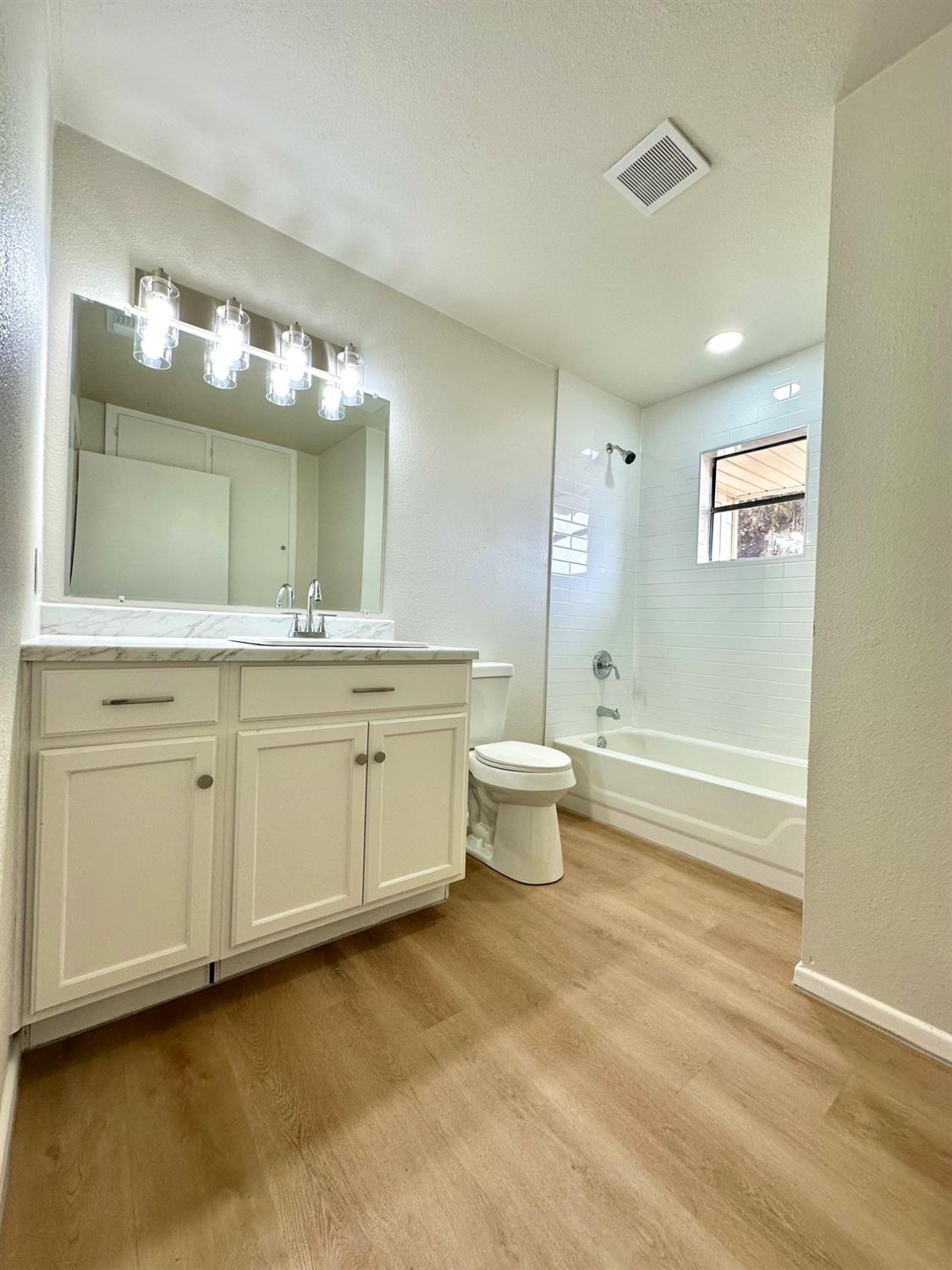 101 15th Street Levelland, TX 79336 - Photo 15 of 29 a spacious bathroom with a double vanity sink a mirror and a bathtub
