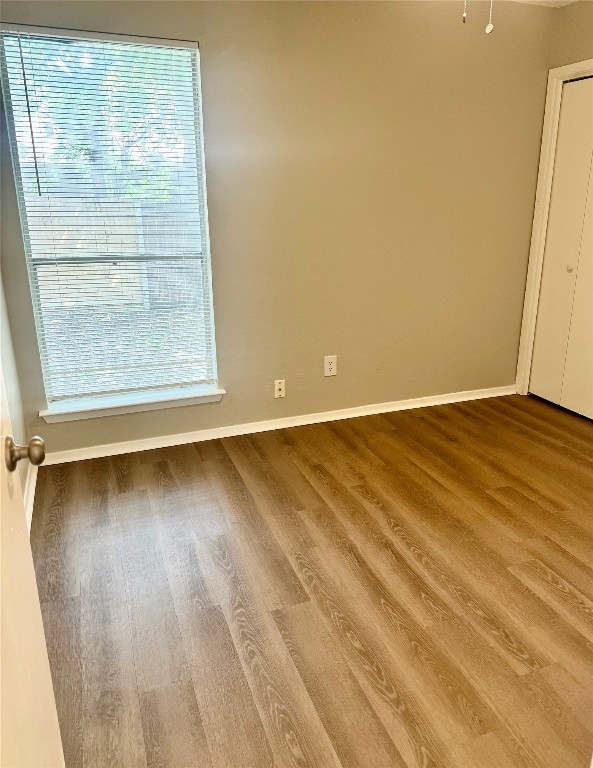 5011 Copperbend Boulevard, Unit A Austin, TX 78744 - Photo 13 of 18 an empty room with wooden floor and windows