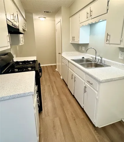 a kitchen with sink a stove and refrigerator