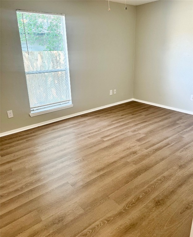 5011 Copperbend Boulevard, Unit A Austin, TX 78744 - Photo 9 of 18 an empty room with wooden floor and windows