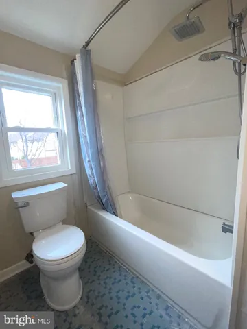 a bathroom with a toilet and bathtub