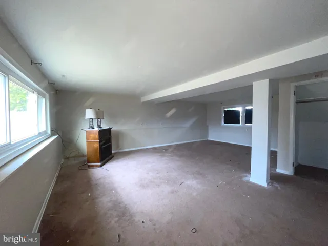 an empty room with fireplace and windows