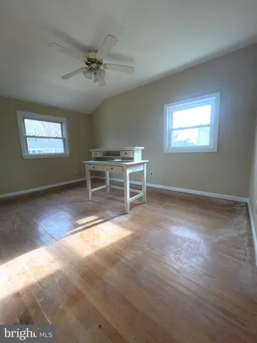a view of a livingroom with furniture a ceiling fan and window