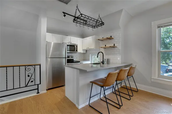 a kitchen with stainless steel appliances granite countertop a sink cabinets and a refrigerator