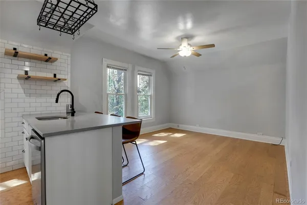 a kitchen with a sink a chandelier stainless steel appliances and cabinets