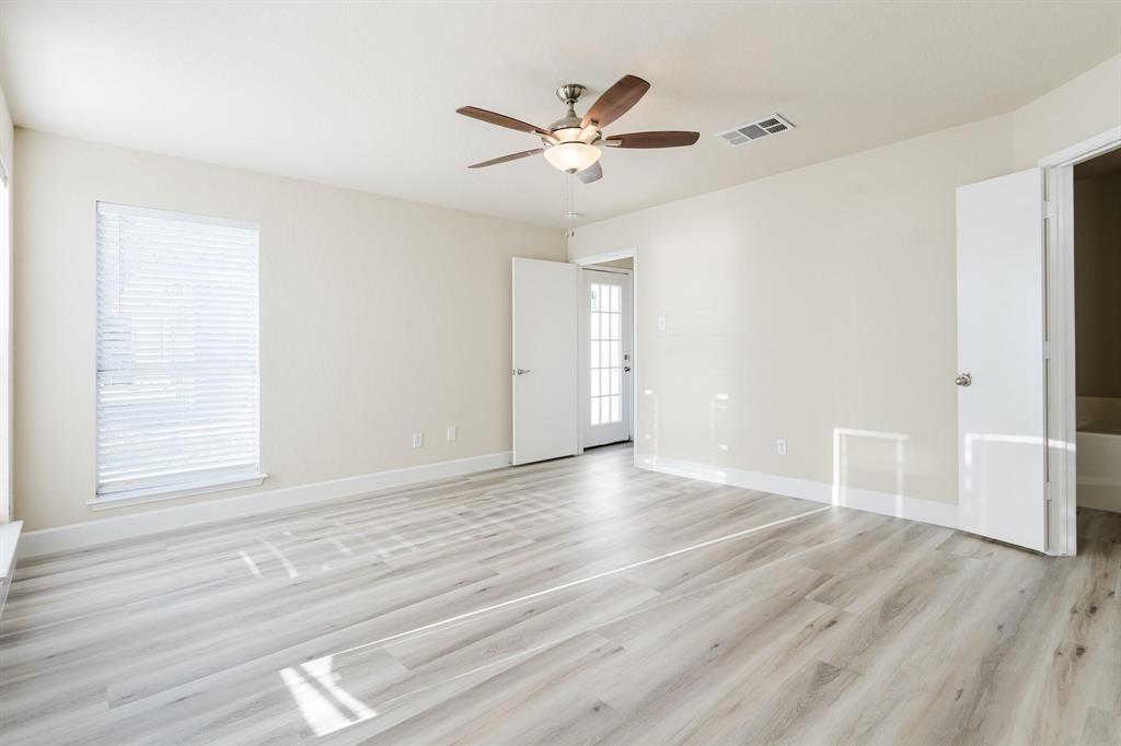 2109 Windjammer Way Rowlett, TX 75088 - Photo 7 of 21 Spare room featuring healthy amount of natural light, light wood finished floors, and a ceiling fan