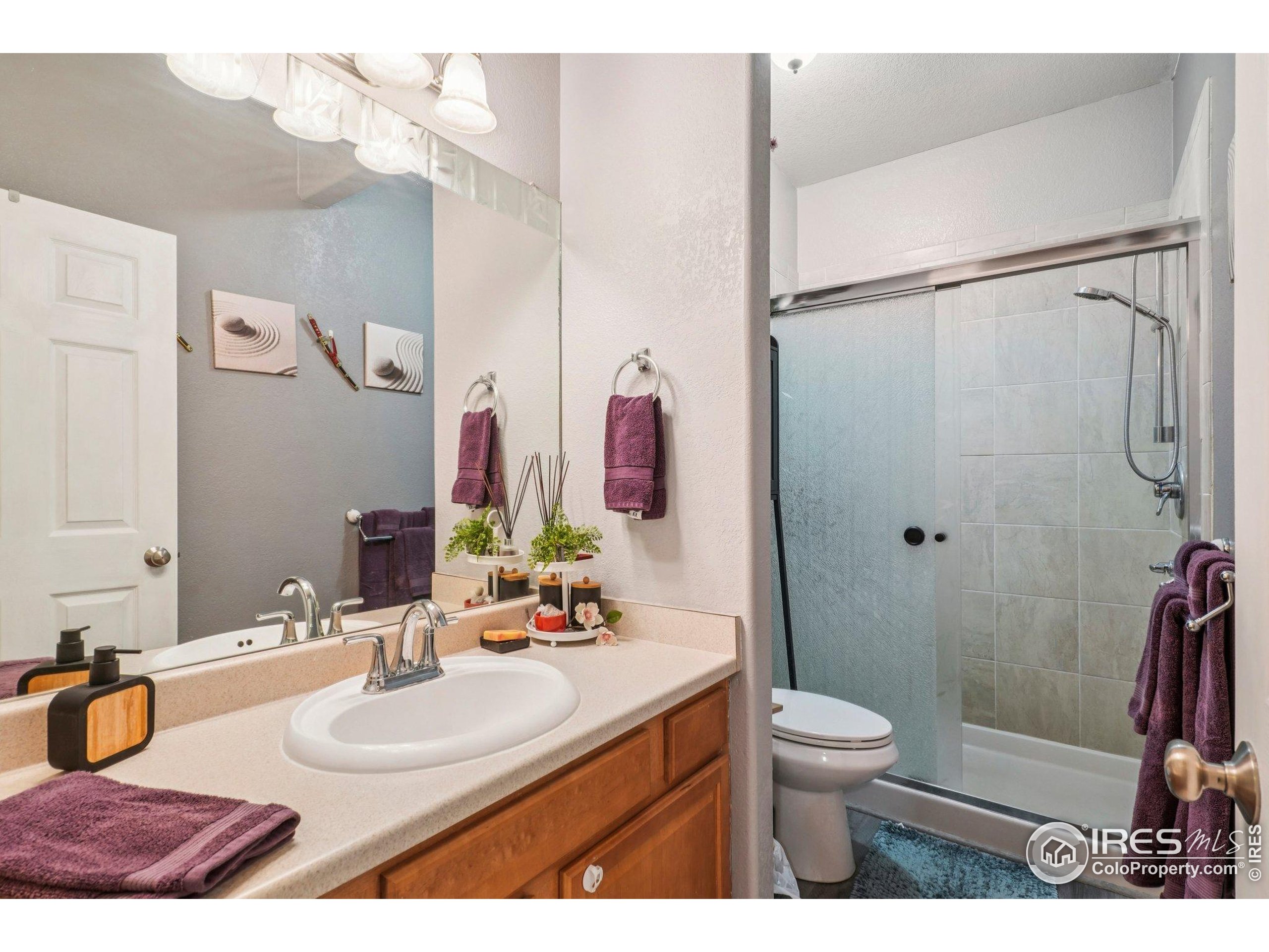 256 Homestead Way Brighton, CO 80601 - Photo 21 of 42 a bathroom with a granite countertop sink mirror vanity and toilet