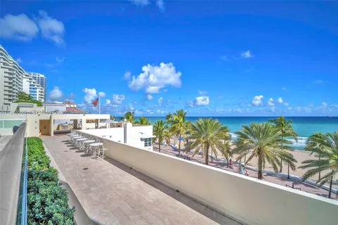 a view of a patio with a table and chairs and potted plants