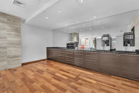 a bedroom with a large bed couch and a flat tv screen next to a window