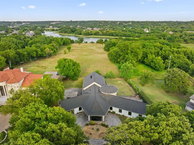 an aerial view of residential houses with outdoor space and lake view