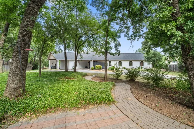 a front view of a house with a yard and shrubs