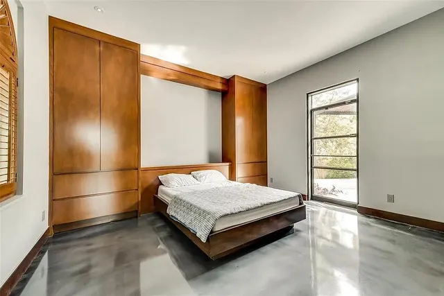 a bed sitting in a spacious bedroom next to a window