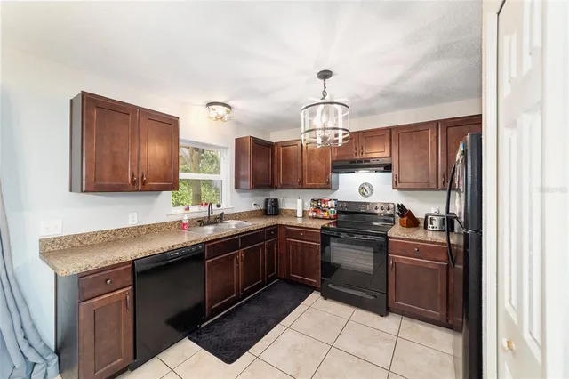 a kitchen with kitchen island granite countertop stainless steel appliances a sink stove and refrigerator