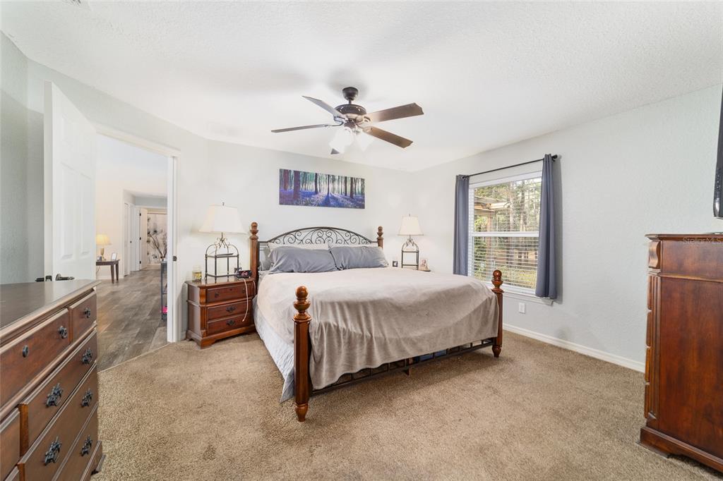 38 Cedar Tree Terrace Ocala, FL 34472 - Photo 8 of 18 a bedroom with a bed and a chandelier