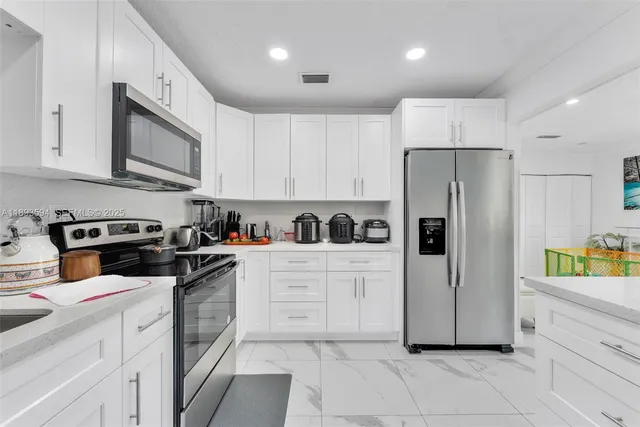 a kitchen with cabinets and stainless steel appliances