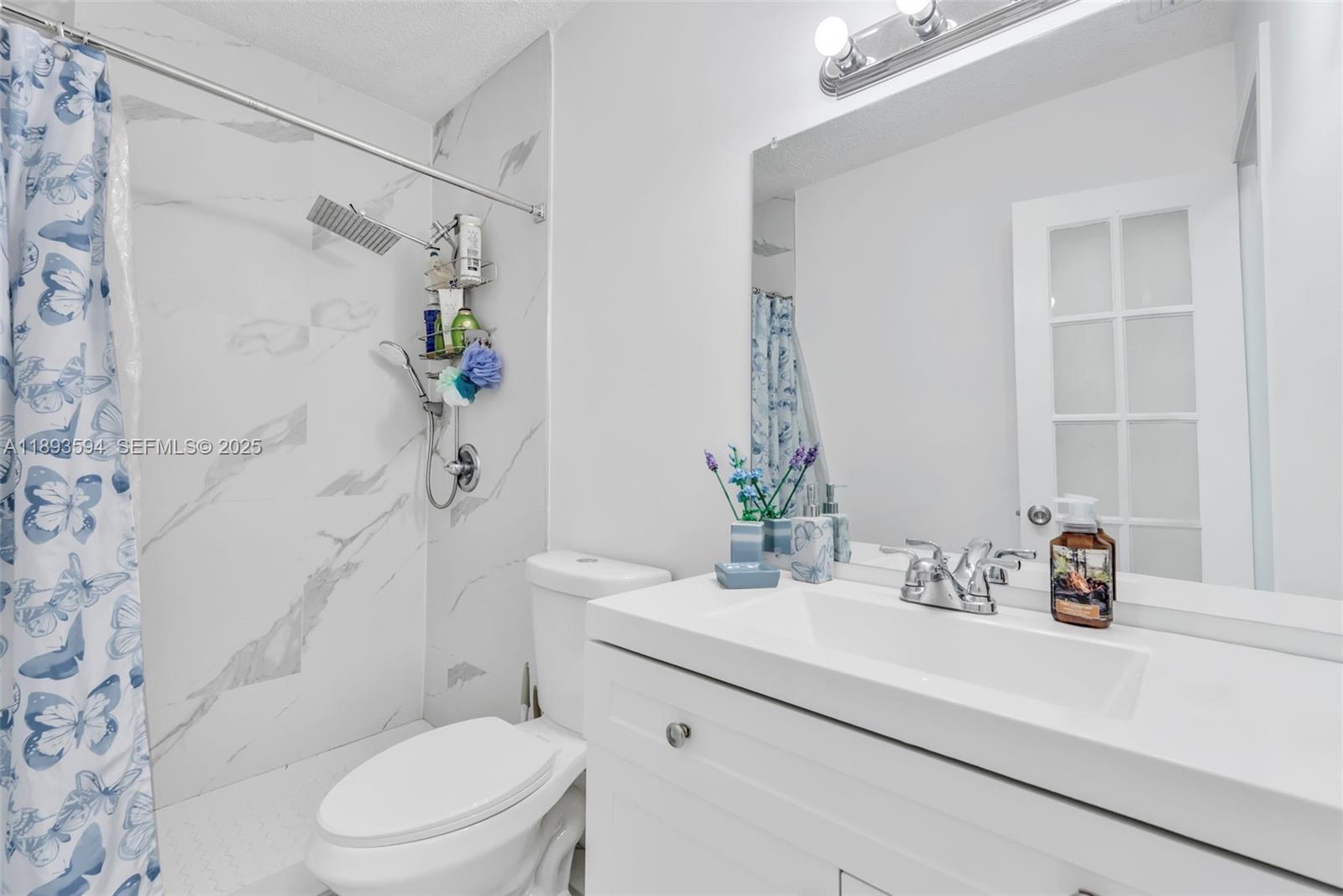 8820 Southwest 27th Street Miami, FL 33165 - Photo 14 of 36 a bathroom with a sink a toilet and shower