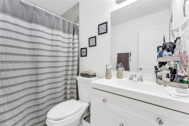 a bathroom with a sink a toilet and shower curtain