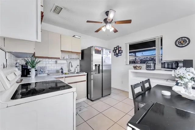 a kitchen with stainless steel appliances kitchen island granite countertop a sink cabinets and refrigerator