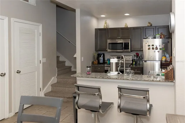 a kitchen with kitchen island a sink cabinets and stainless steel appliances