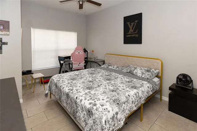 a bed sitting in a bedroom next to a window with chair