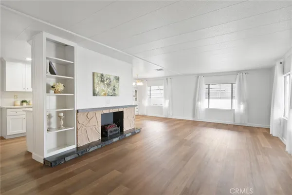 wooden floor fireplace and windows in an empty room