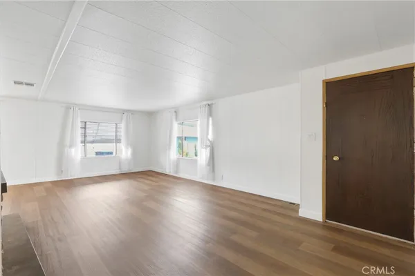 a view of wooden floor and windows in a room