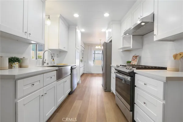 a kitchen with stainless steel appliances sink refrigerator and cabinets
