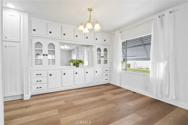 a view of a hallway with chandelier and wooden cabinet