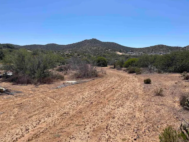 a view of a dry yard with mountains in the background