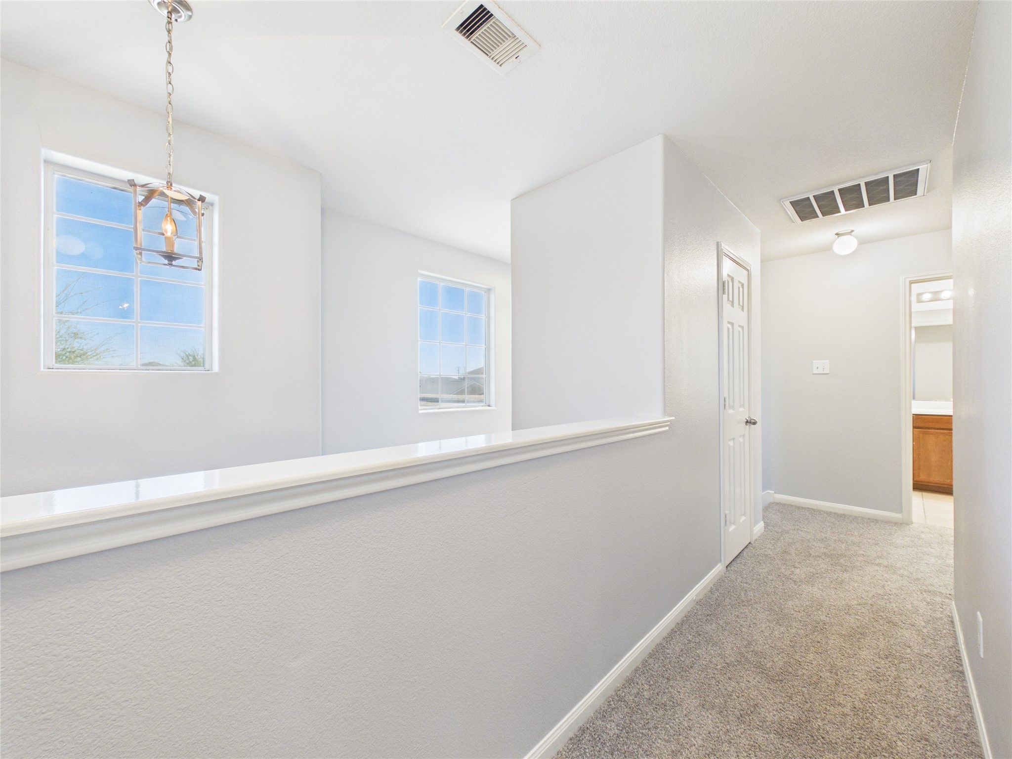 911 Marigold Road Baytown, TX 77521 - Photo 25 of 33 Bright, airy hallway with large windows for abundant natural light and a modern pendant light fixture.
