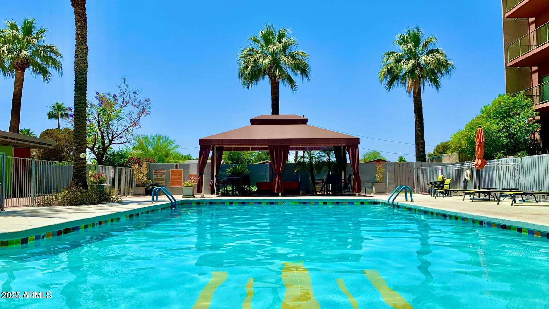 4750 North Central Avenue, Unit L8 Phoenix, AZ 85012 - Photo 39 of 55 a swimming pool with outdoor seating yard and palm trees