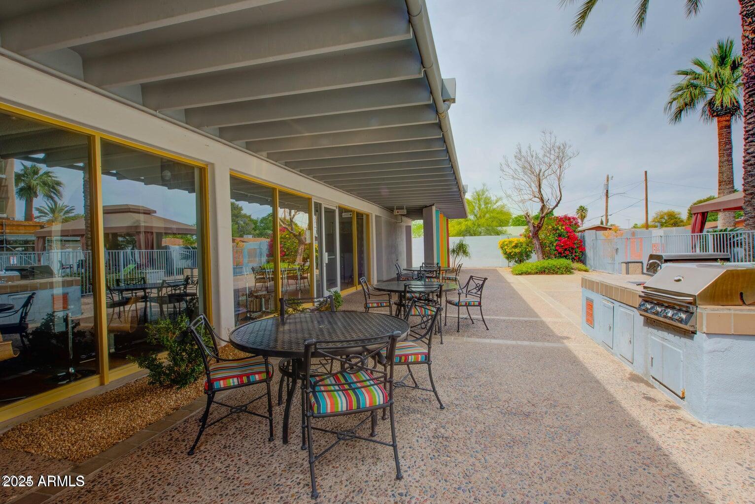 4750 North Central Avenue, Unit L8 Phoenix, AZ 85012 - Photo 41 of 55 a view of a patio with table and chairs potted plants with floor to ceiling window