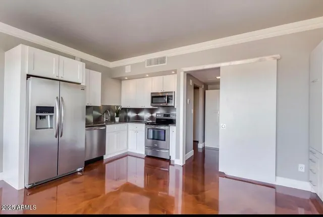 a kitchen with stainless steel appliances granite countertop a refrigerator and a stove top oven