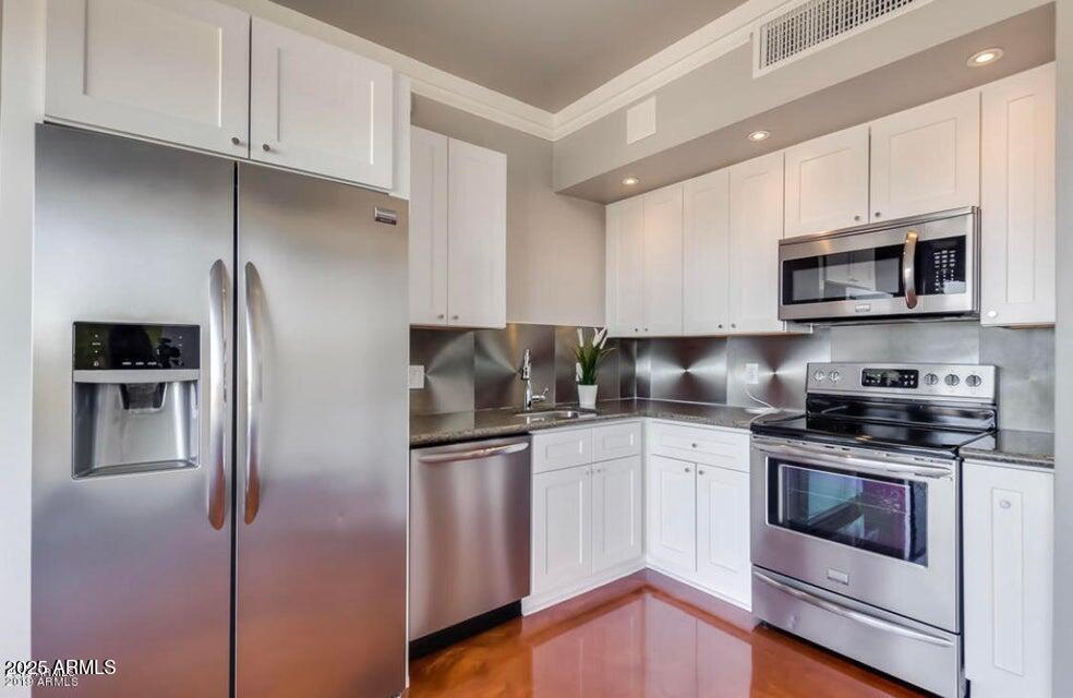 4750 North Central Avenue, Unit L8 Phoenix, AZ 85012 - Photo 9 of 55 a kitchen with stainless steel appliances granite countertop a refrigerator and a stove top oven